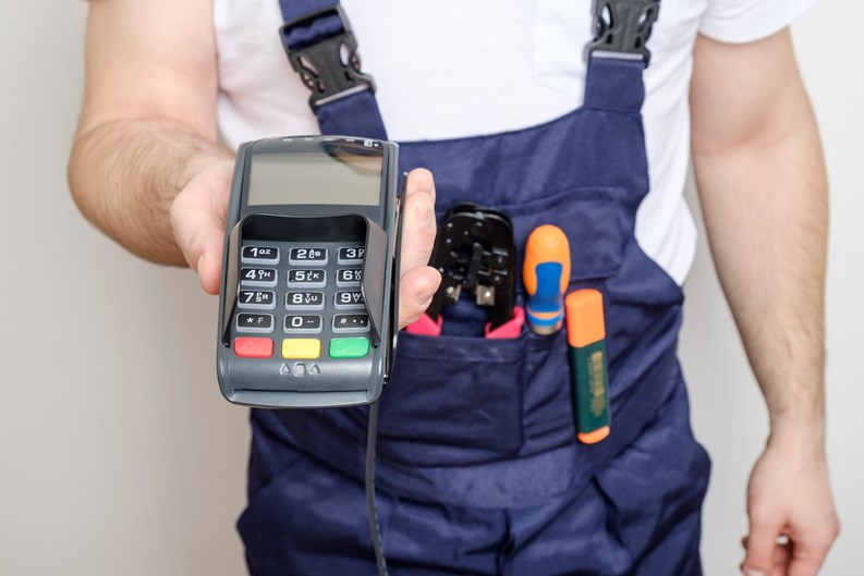 Man with tools holding bank payment terminal. Salary concept