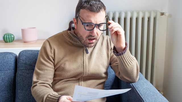 One man worried about bills reading energy increase costs