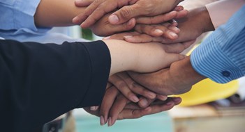 Fiduciary Duty Explained Partners hands together teamwork group of business people meeting in firm company office. Diversity Hands join empower partnership teams connection community. Success Mergers acquisitions partnership