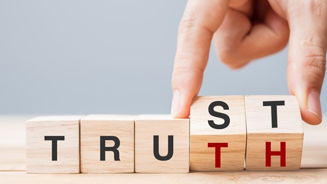 Business man hand change wooden cube block with TRUST and TRUTH business word on table background. Trustworthy, faith, beliefs and honesty concept