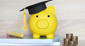 Money Mindfulness Graduation hat on piggy bank with stack of coins money on wooden background, Saving money for education concept