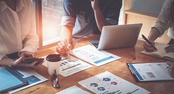 Better Meetings, Better Communities Businessman holding pens and holding graph paper are meeting to plan sales to meet targets set in next year. audit budget and financial concept