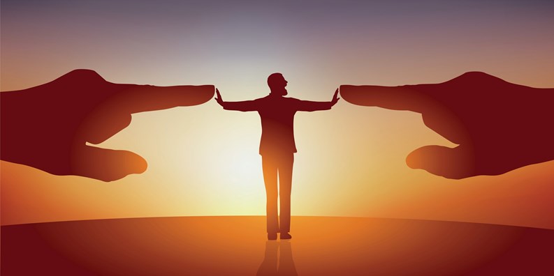 Concept of opposition with a man with his arms spread who symbolically repels two huge hands pointing at him to designate him as a scapegoat.