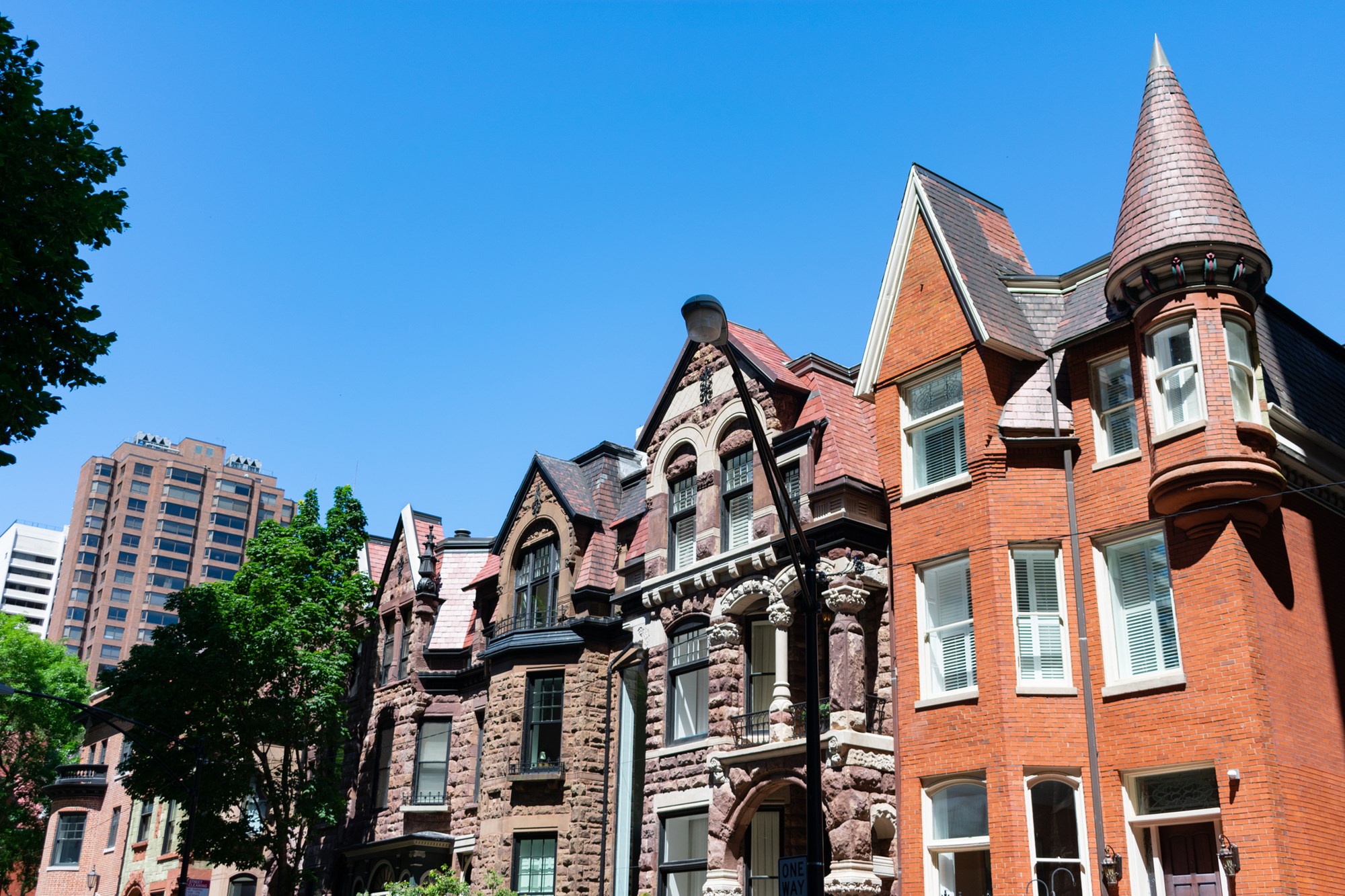 An upwards view of a row of fancy large old homes in the Gold Coast neighborhood of Chicago