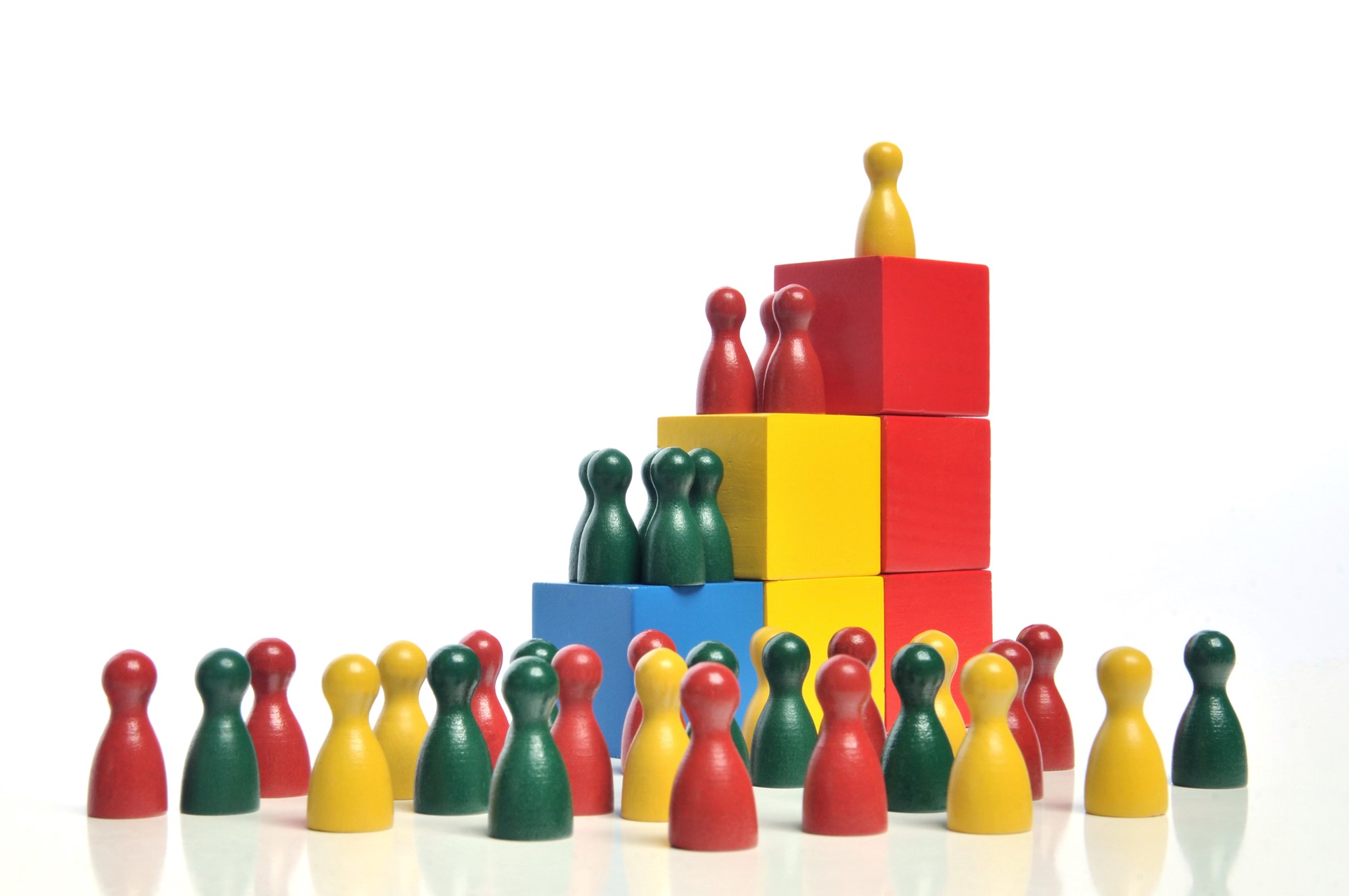 Hierarchy - Multicolored wooden toy blocks and figures on white background