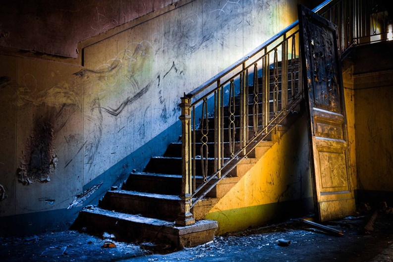 The Ghost House: interior of an abandoned house, very dirty and messy, with rotten walls and staircases.